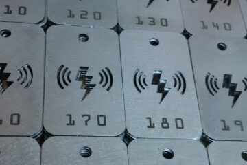 metal number tag: silver plates with lightening bolts and various numbers engraved into them.